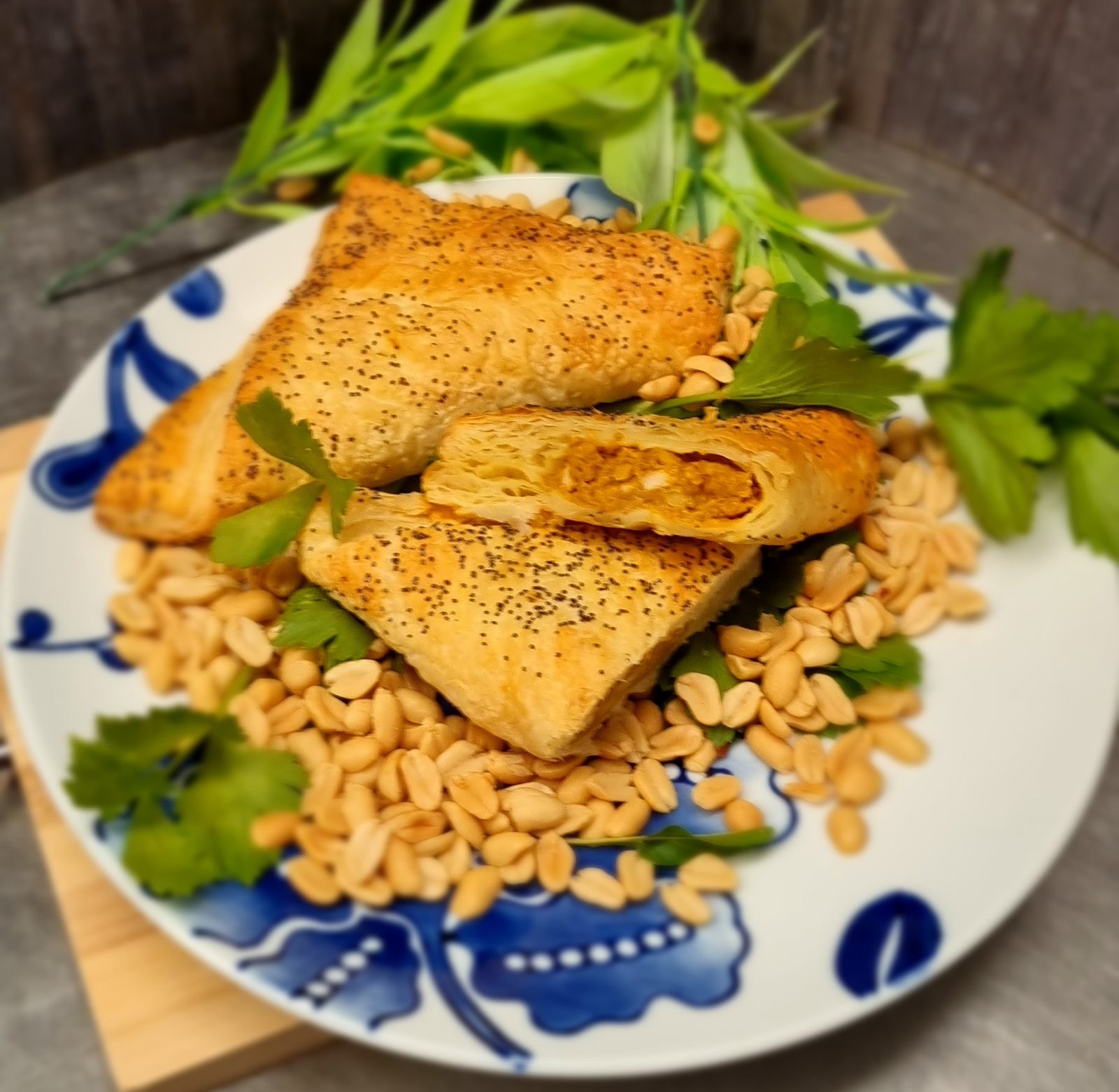 Simply Pies satay-style triangular pasties with poppy seed pastry on a blue ceramic plate